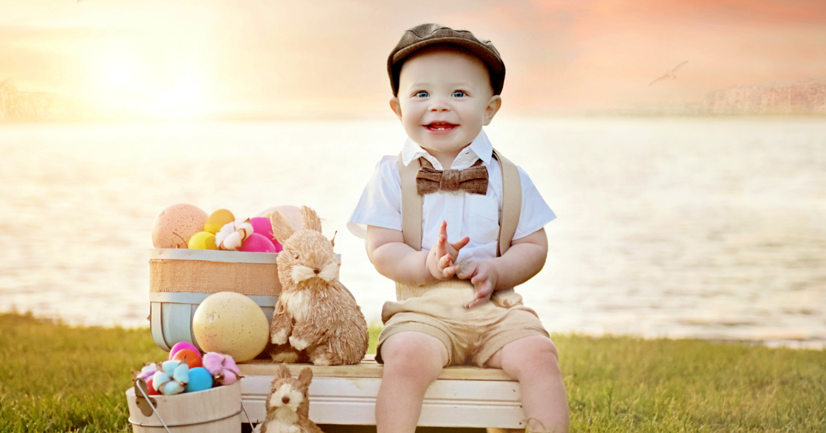 baby boy in outfit with hat next to easter supplies