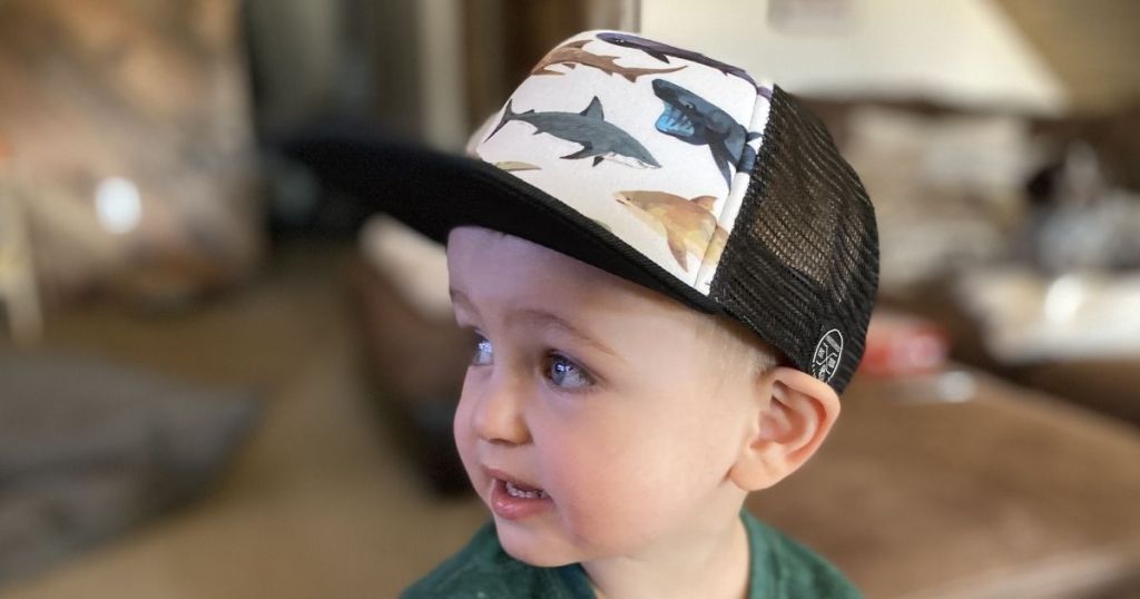 child wearing a hat with fish on it