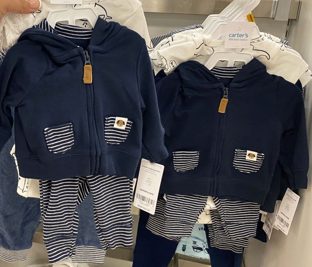 person holding up carters boys outfit set at store