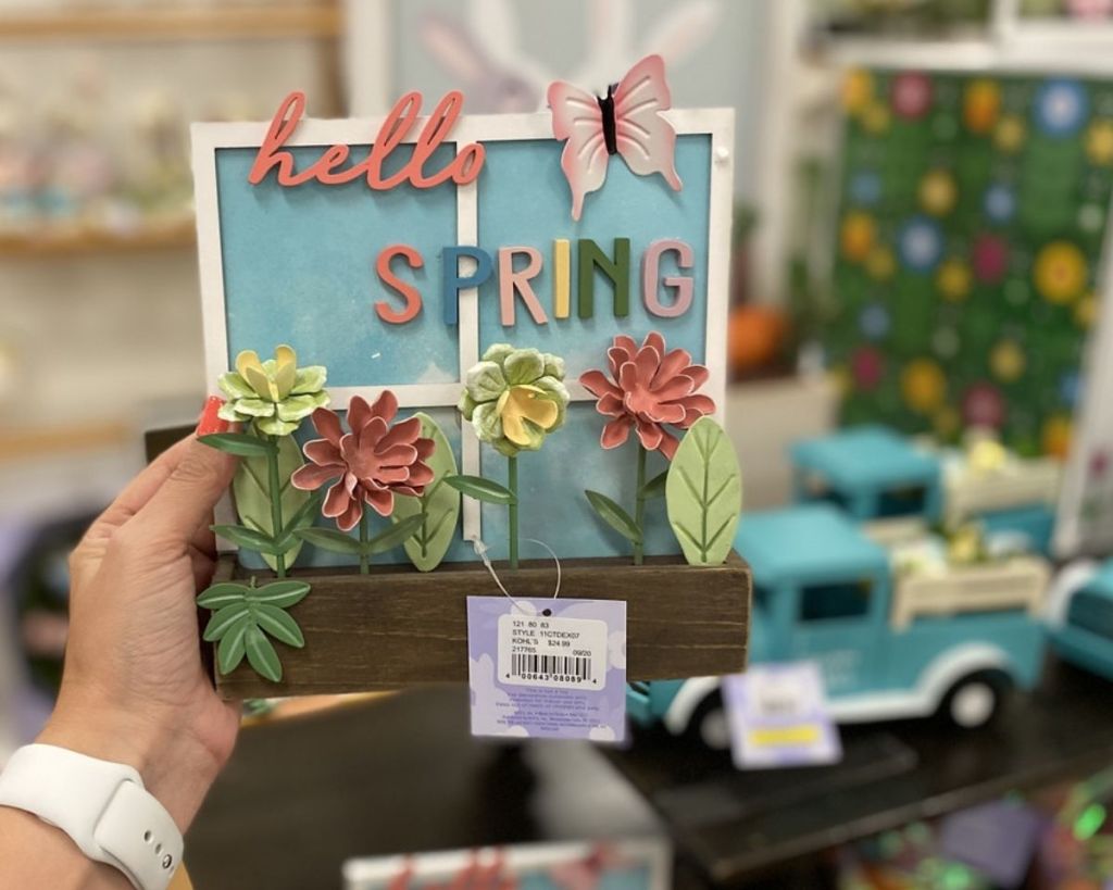 hand holding Celebrate Easter Together Hello Spring Sign in store