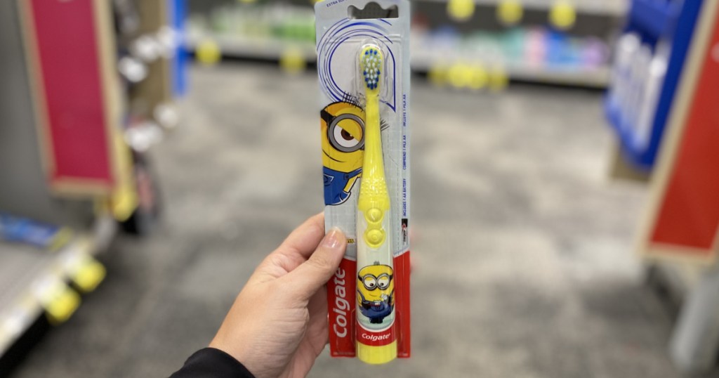 hand holding yellow toothbrush 