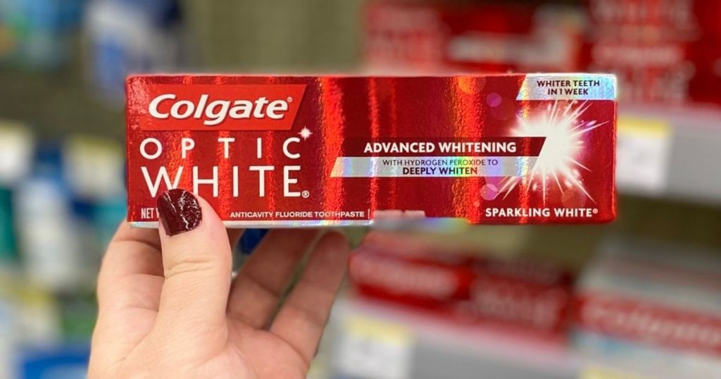 hand holding Colgate Optic White Toothpaste