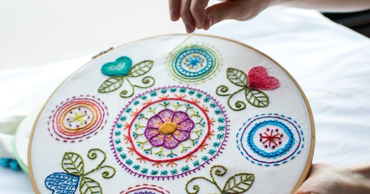 person embroidering a design