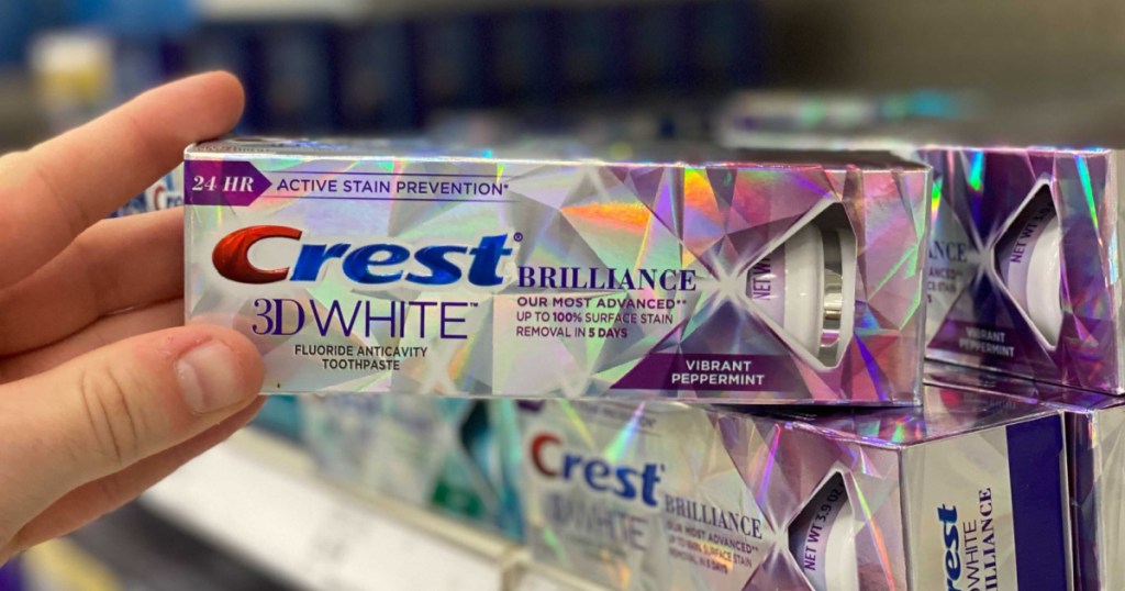 hand holding out Crest 3D White Brilliance Toothpaste