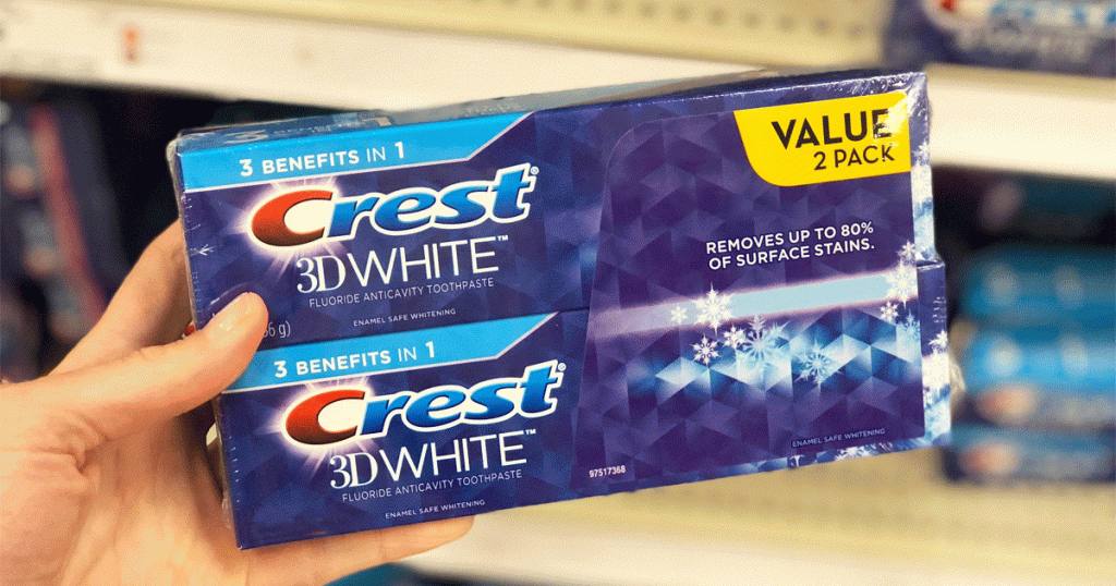 person holding up a 2-pack of crest 3d white toothpaste