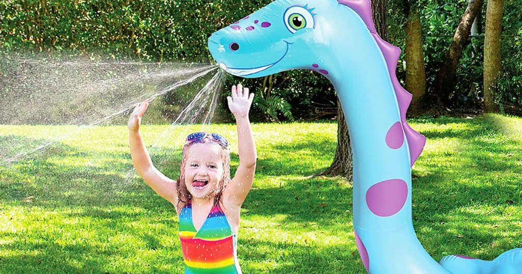 girl standing under dragon inflatable sprinkler