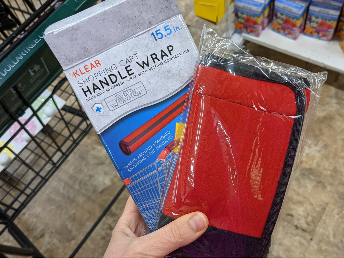 hand holding a shopping cart handle wrap in and out of packaging