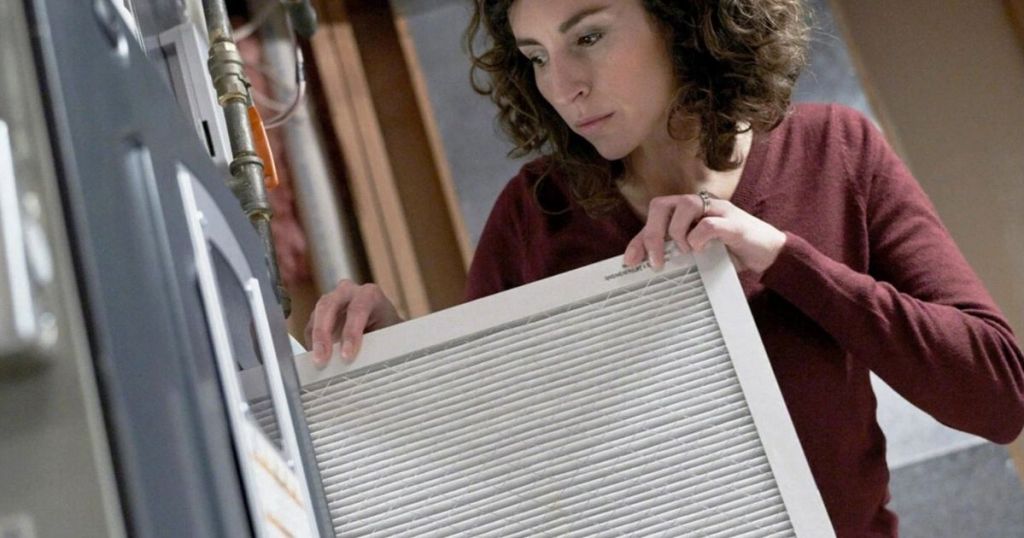 woman putting an air filter in her house