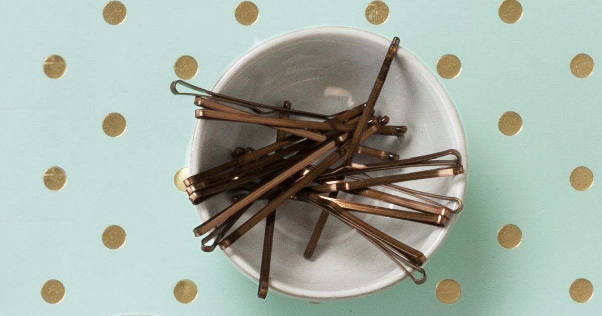 bowl of Goody Bobby Pins on mint green with gold dot background