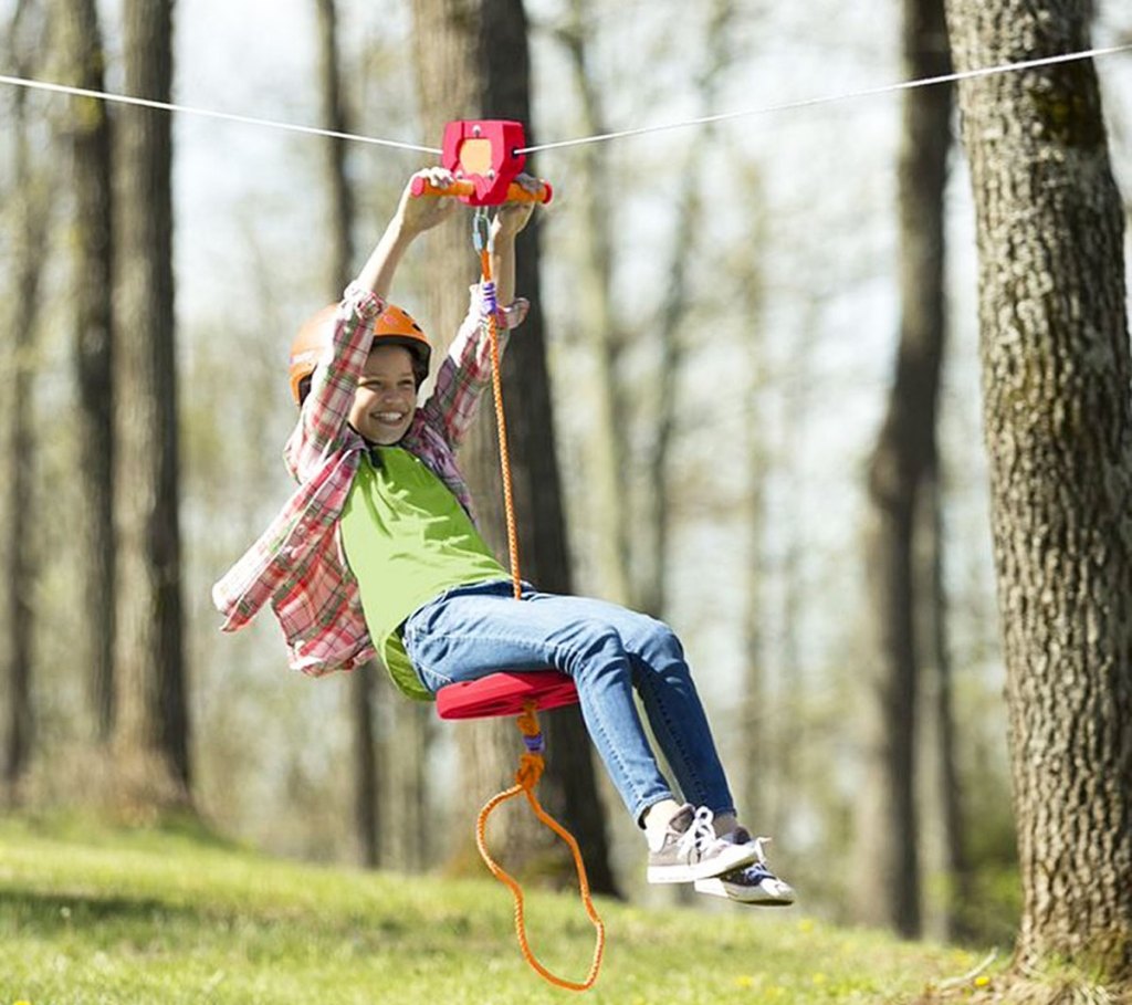 girl riding on zip line toy