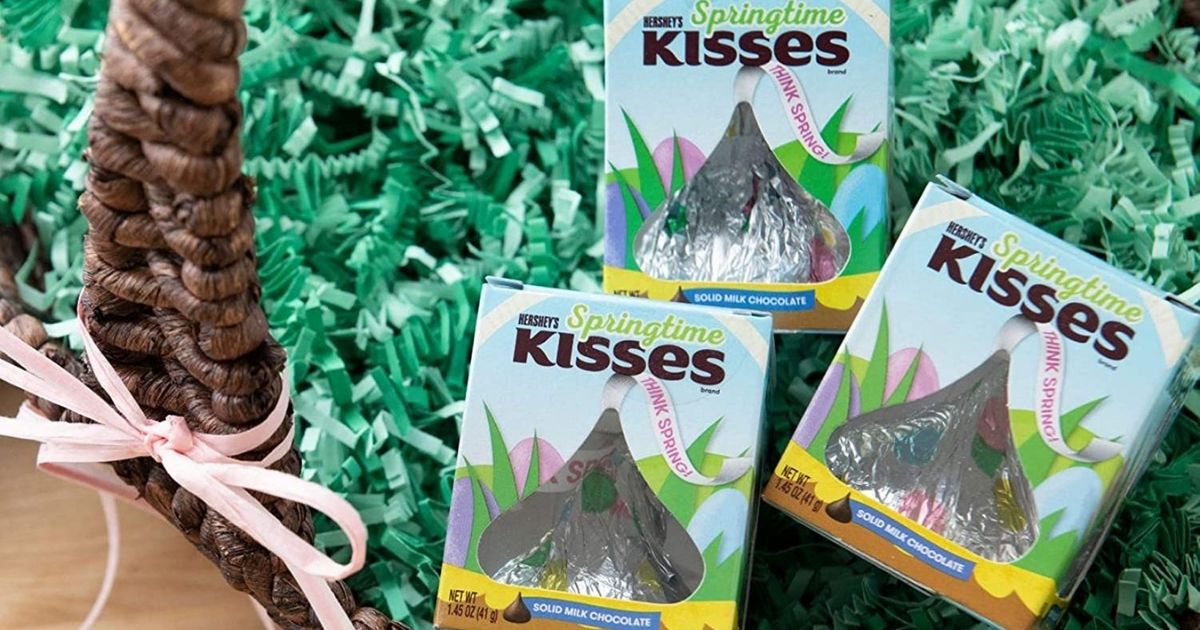 three Hershey's Springtime Kisses in boxes displayed on green shredded grass in an Easter basket