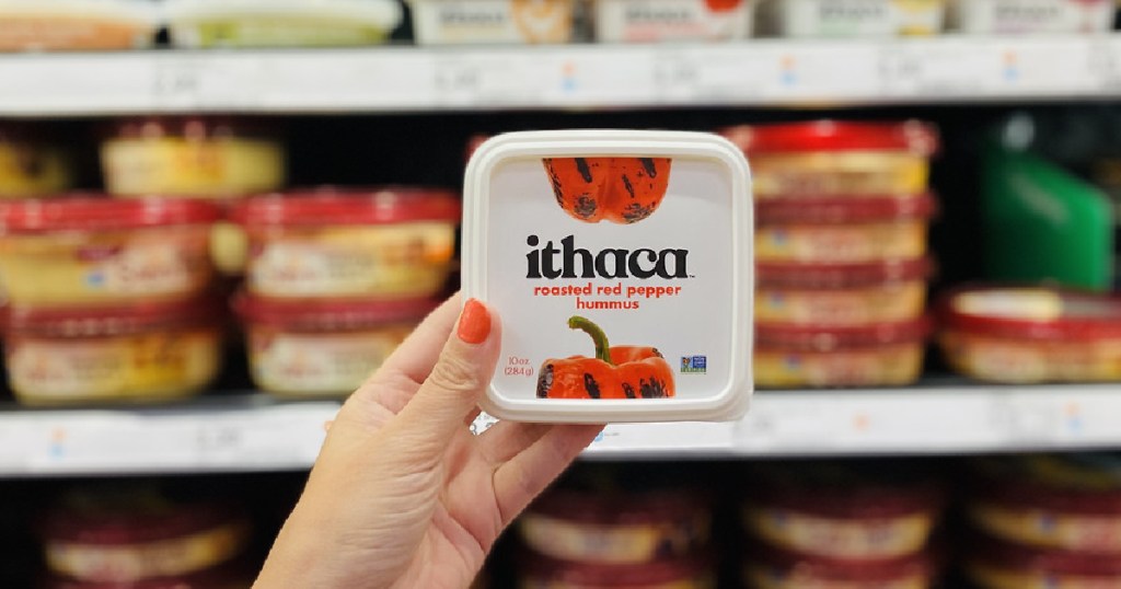 woman holding Ithaca red pepper hummus