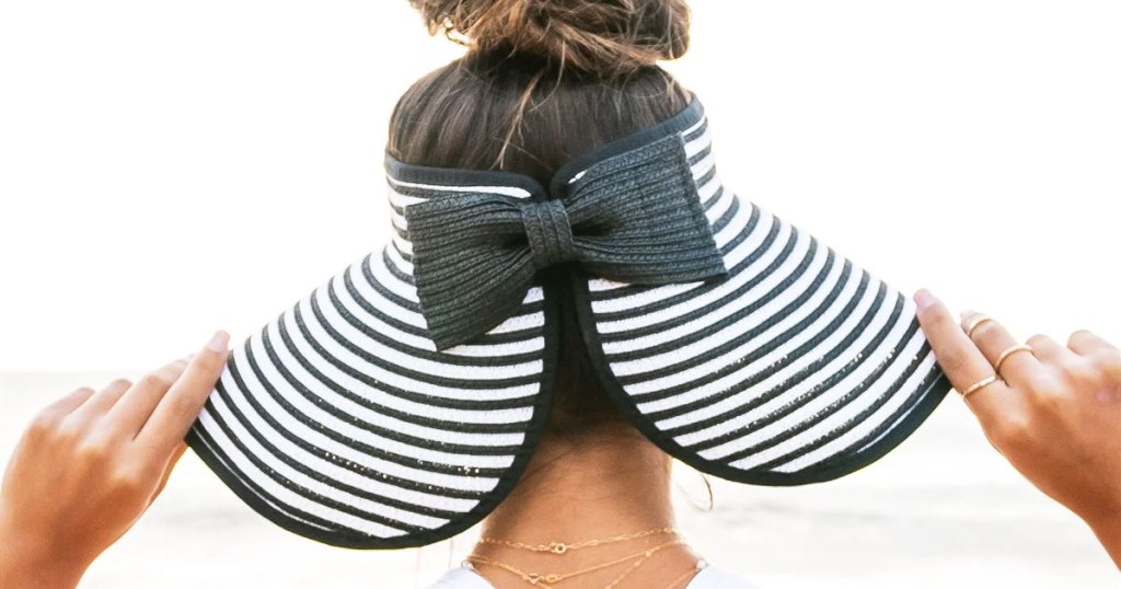 woman wearing a striped visor with bow at the back and hair in a messy bun