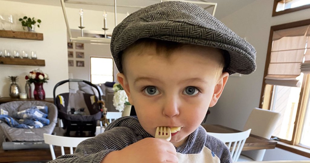 toddler boy in kitchen wearing vintage hat