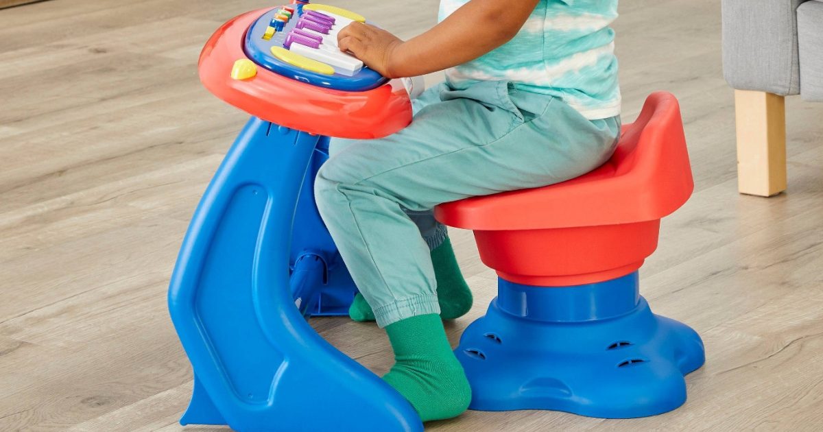 boy sitting on toy musical station with keyboard