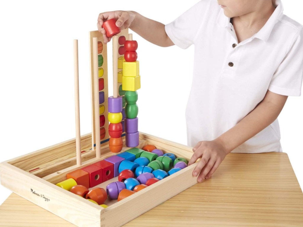 boy playng with melissa and doug sequencing set
