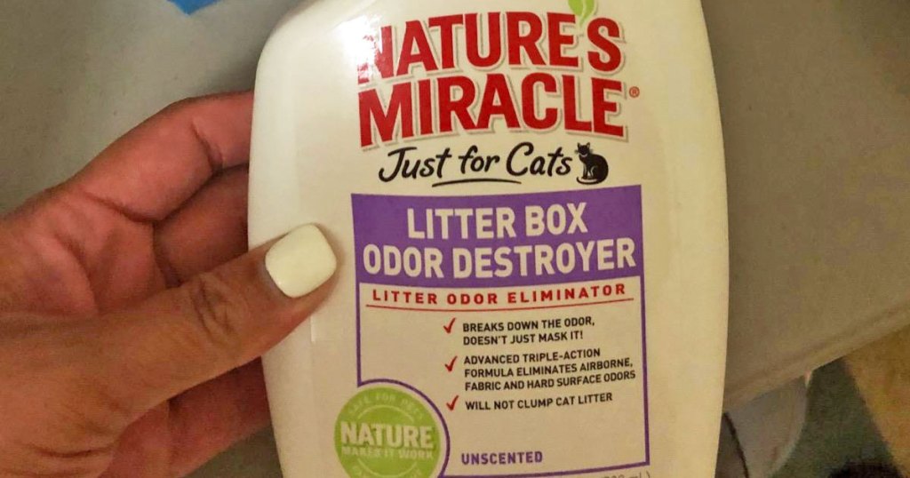 person holding a bottle of nature's miracle litter box spray