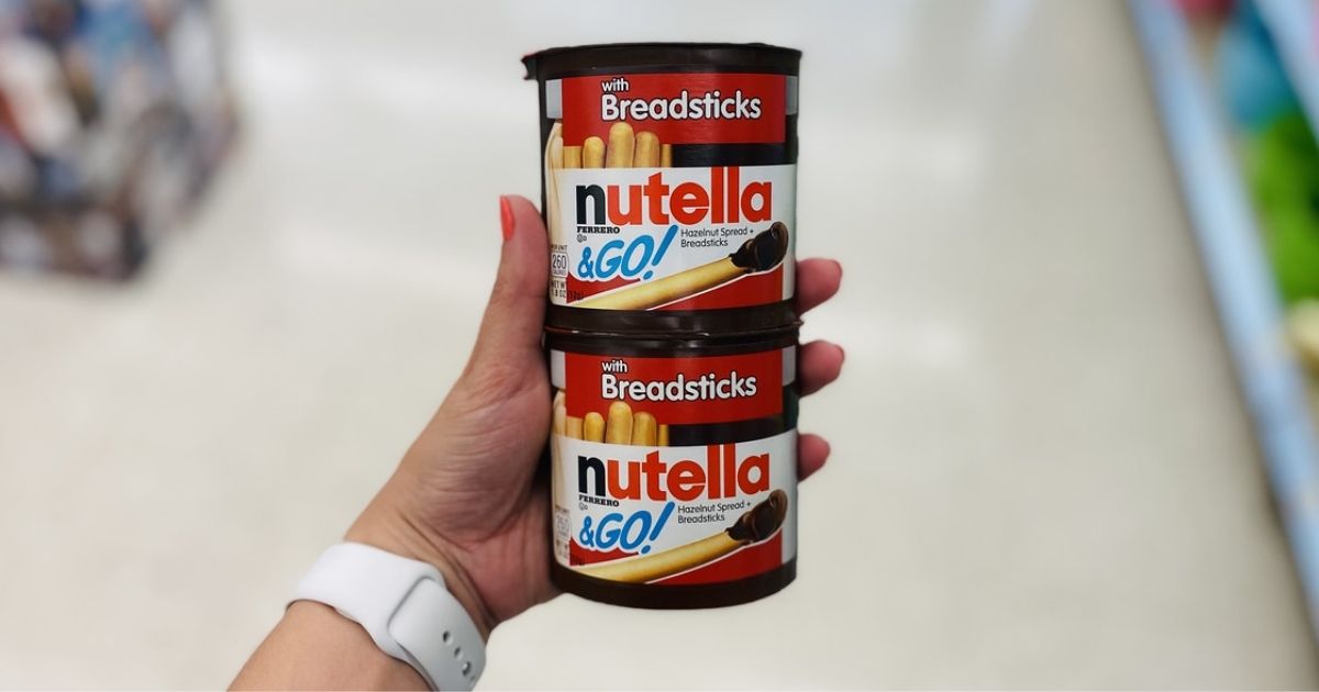 hand holding 2 Nutella snack packs stacked on top of each other in a store aisle
