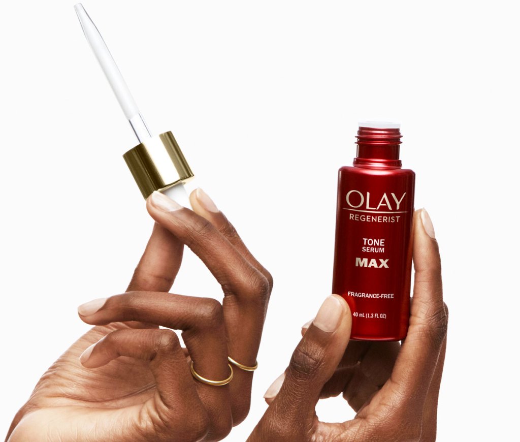 woman's hand holding bottle and dropper for olay serum