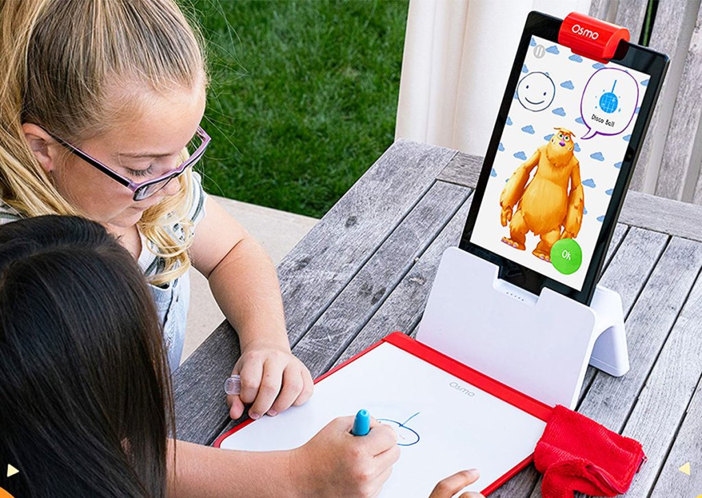 two girls drawing a monster display on osmo tablet