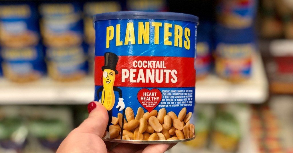 woman's hand holding large jar of cocktail peanuts