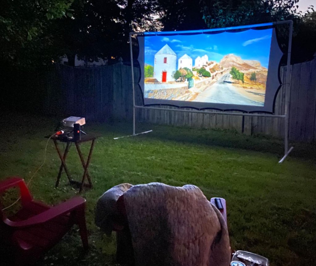 movie projector and screen set up in backyard