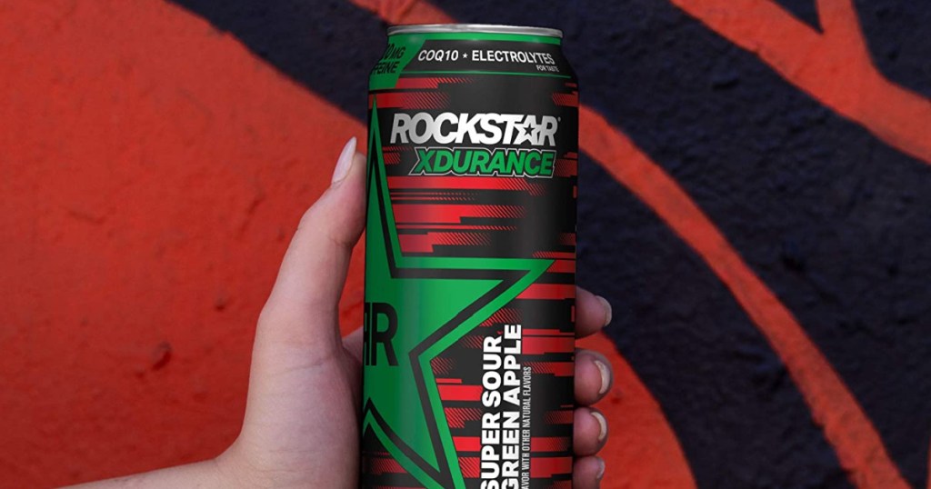 Hand holding a can of Rockstar Sour Apple drink