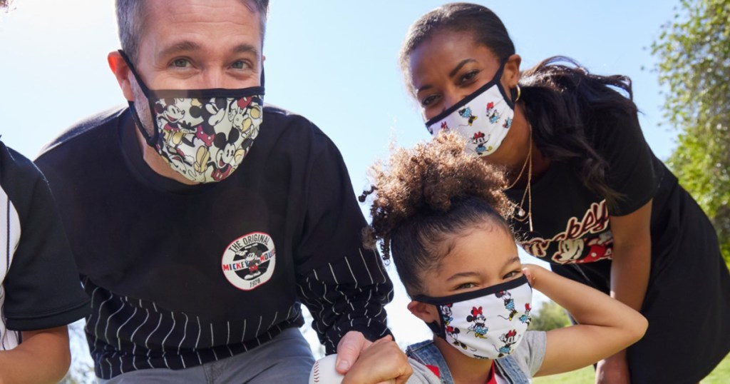 man, woman, and child wearing minnie mouse and mickey mouse face masks