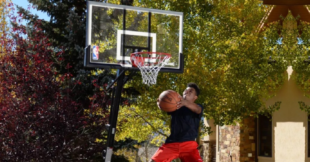 boy jumpng in the air making a shot at a basketball hoop