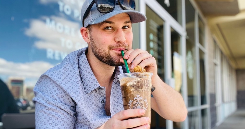 man sipping starbucks frappuccino outside