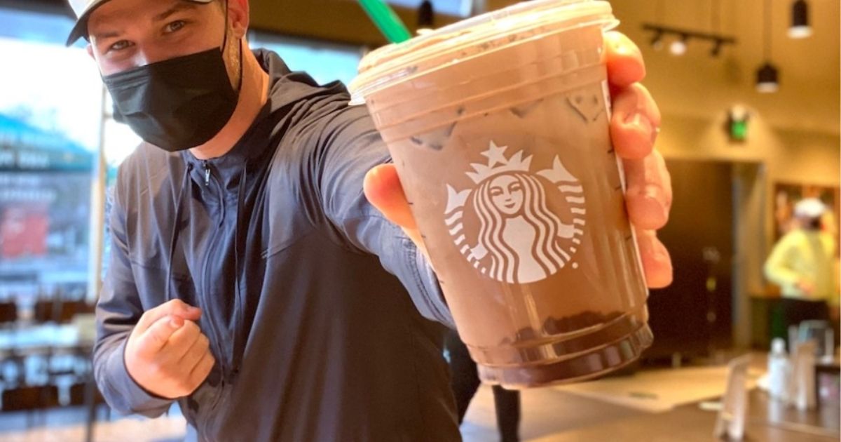 man holding Starbucks Drink
