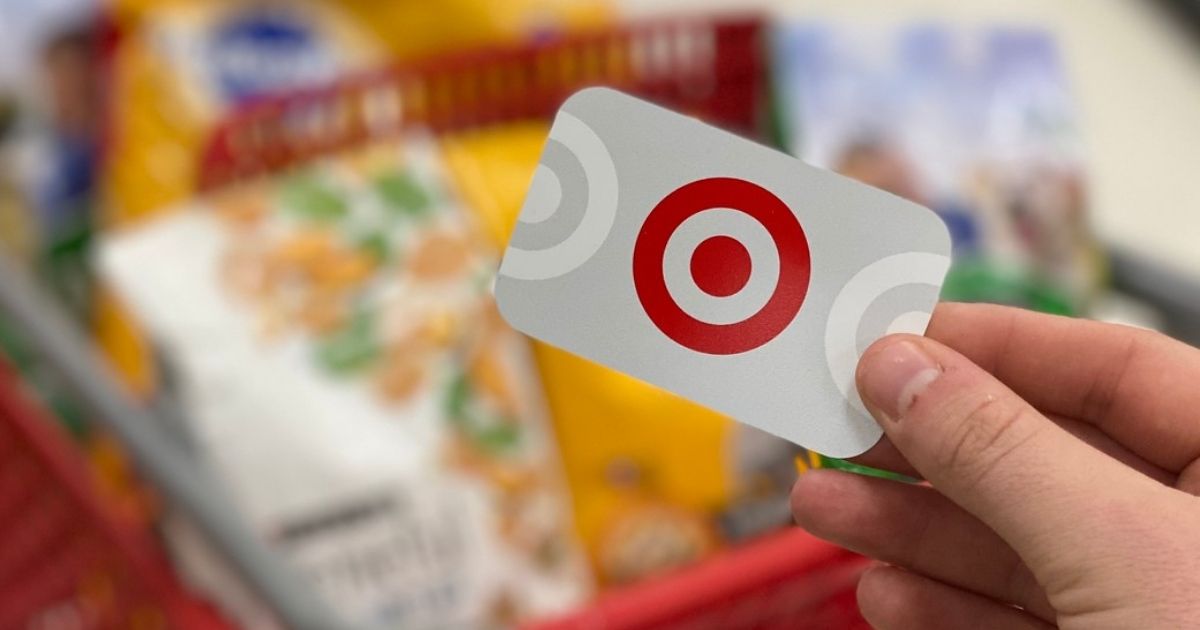 hand holding Target Gift Card with pet food in target cart