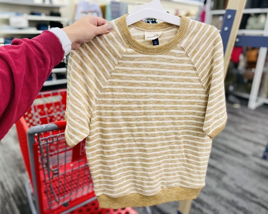 hand holding Target Universal Thread SS Sweatshirt on hanger in front of Target cart