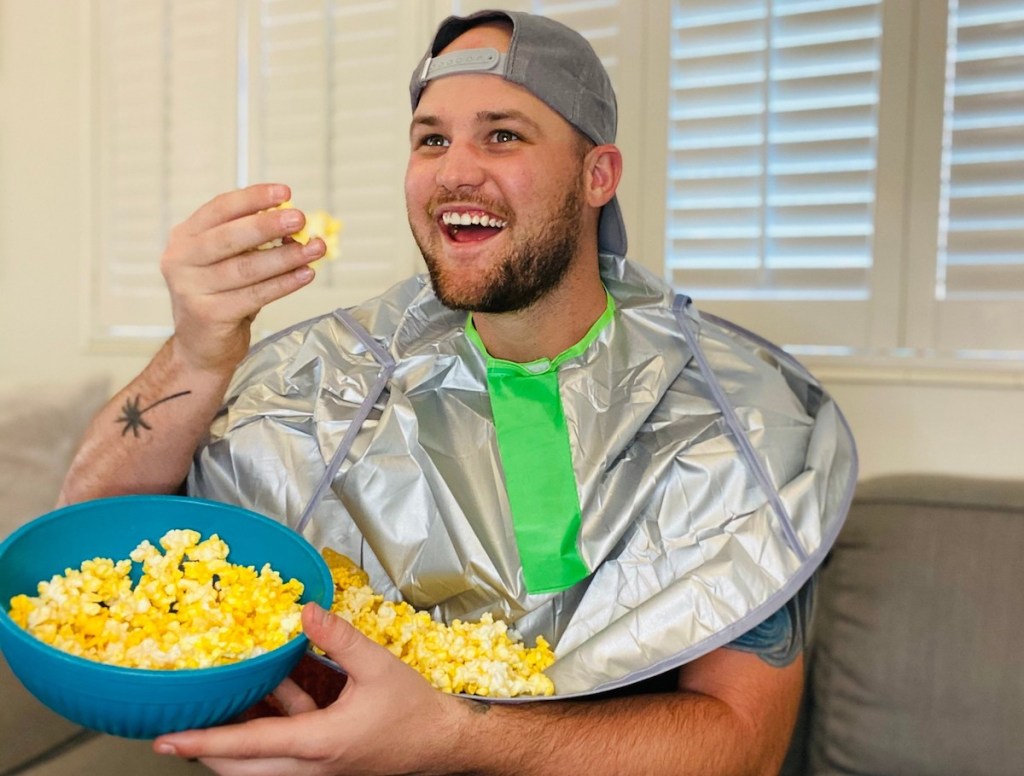 man wearing adult bib with popcorn holding bowl