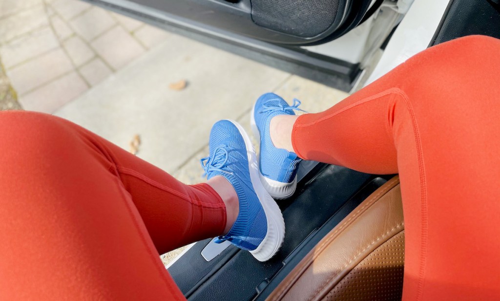 close up of legs wearing orange leggings and blue sneakers