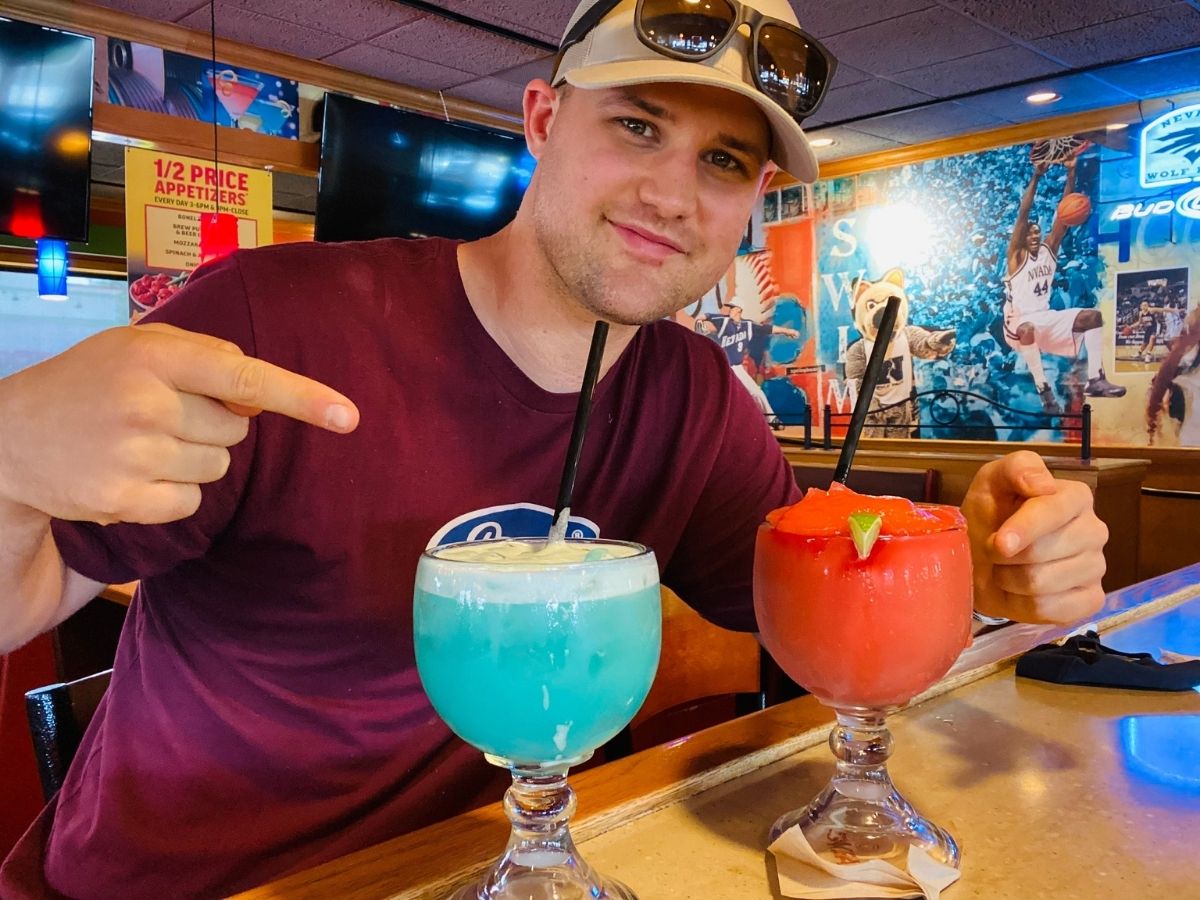 man pointing at blue Bahama mama drink and daiquiri drink 