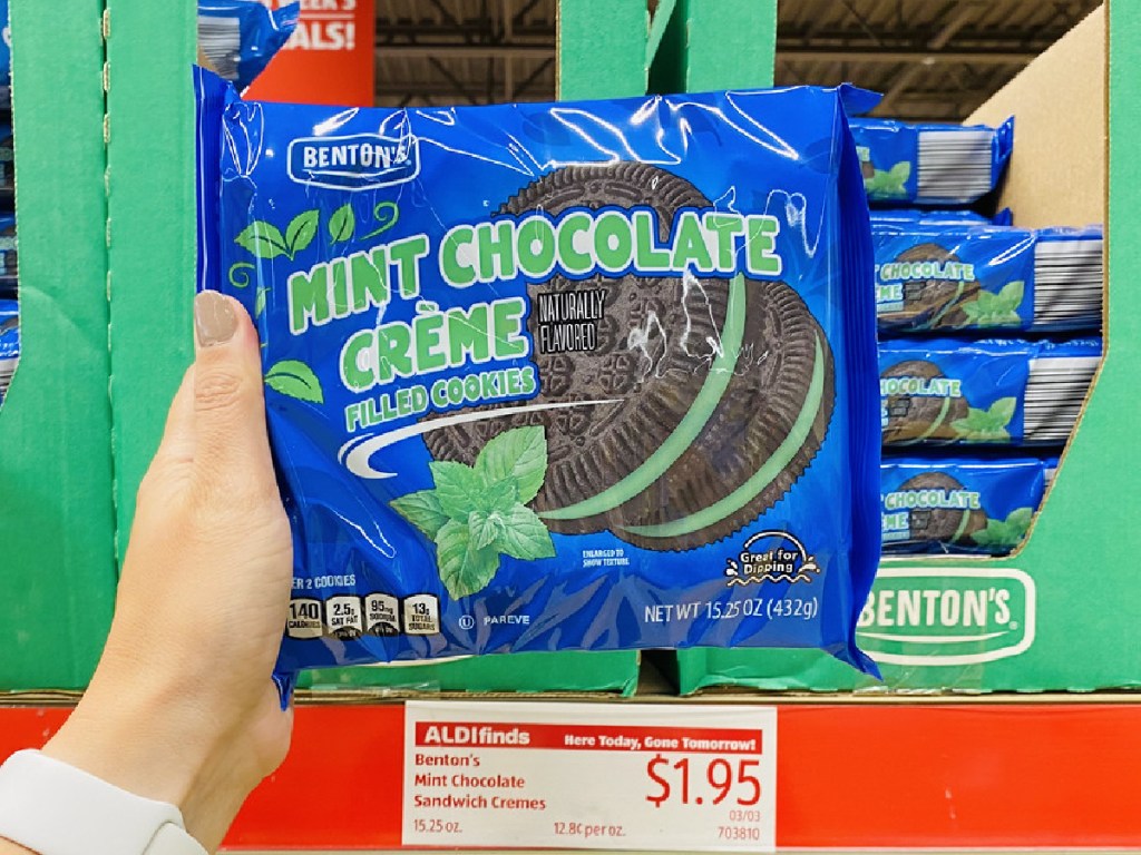 hand holding package of cookies by store display