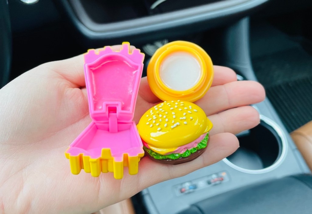 hand holding open burger and fries lip balm in car - April fools pranks