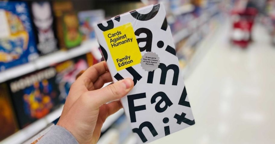 hand holding cards against humanity family edition card game in store