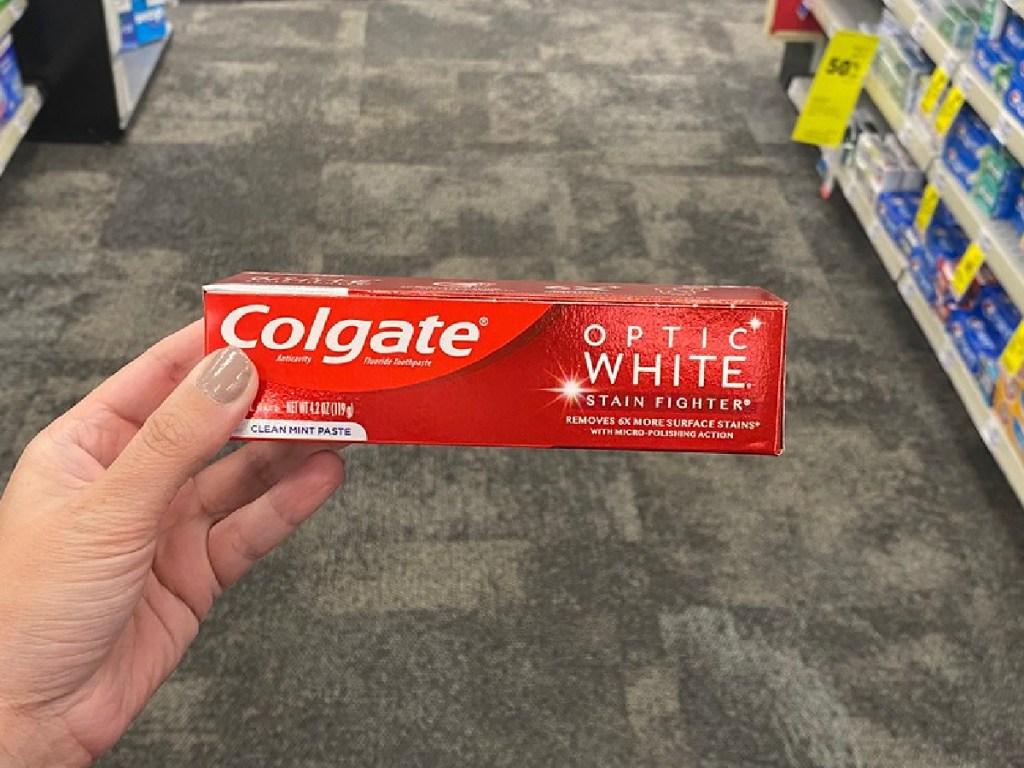 colgate optic white toothpaste in woman's hand at cvs