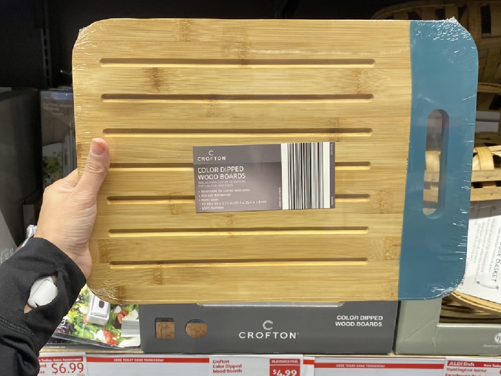 hand holding wood cutting board by store display