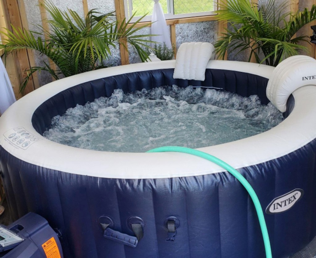 hose filling up inflatable hot tub in she shed