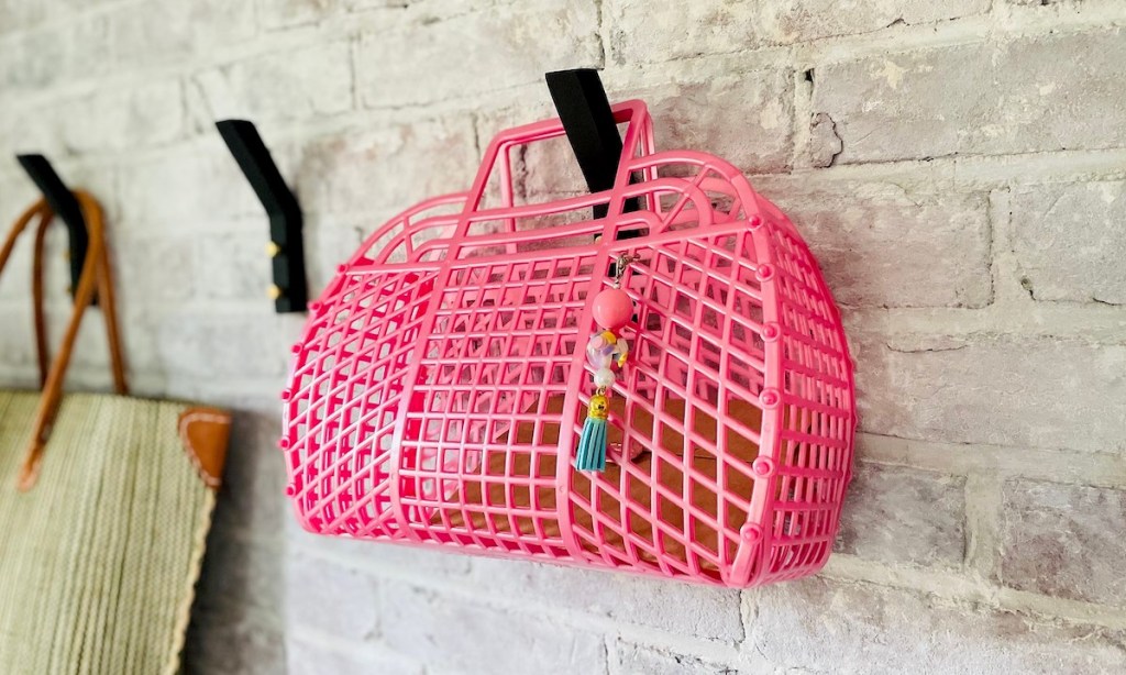 pink jelly bag hanging from hook on brick wall