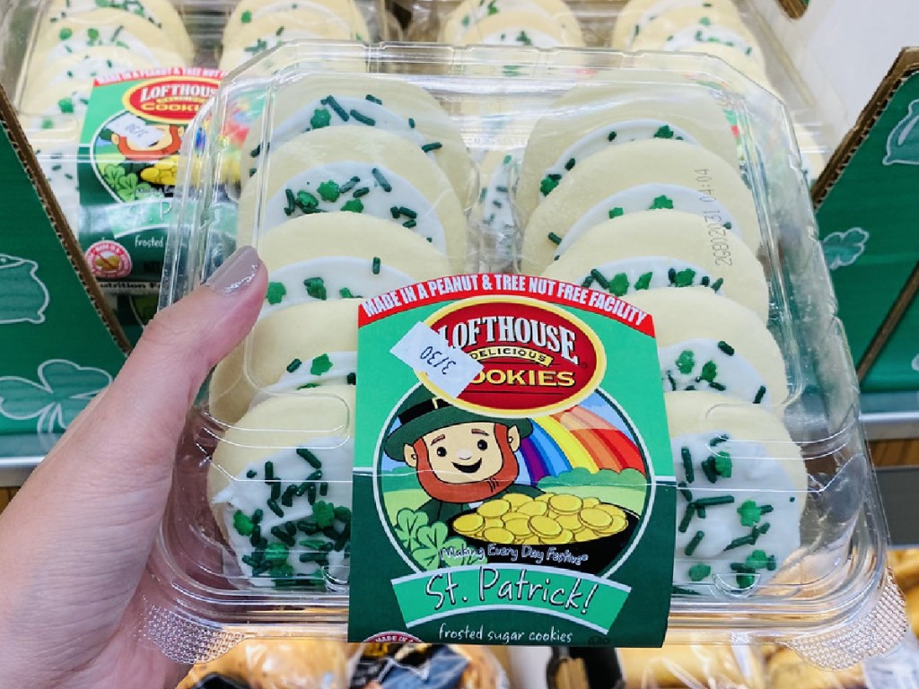 hand holding package of cookies by store display