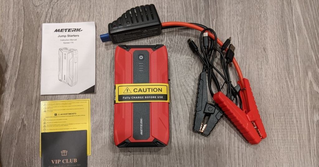 red and black portable jump start kit and cords and manual
