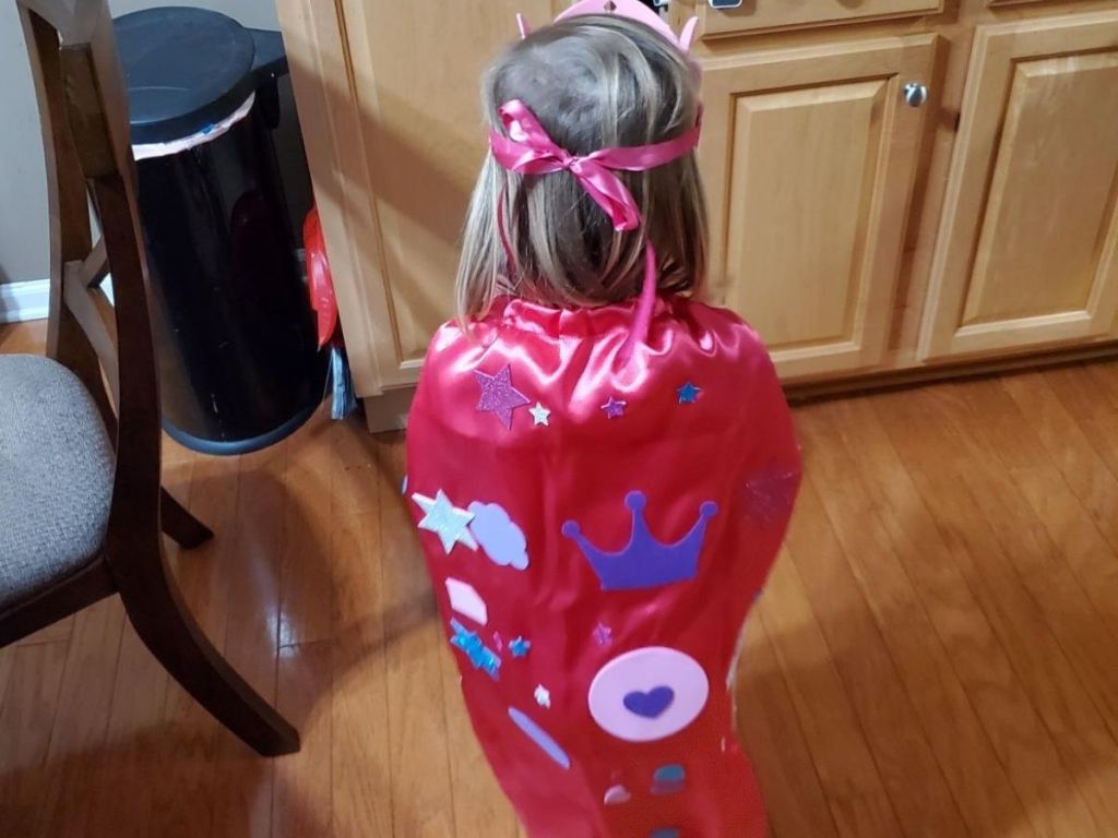 little girl wearing princess cape