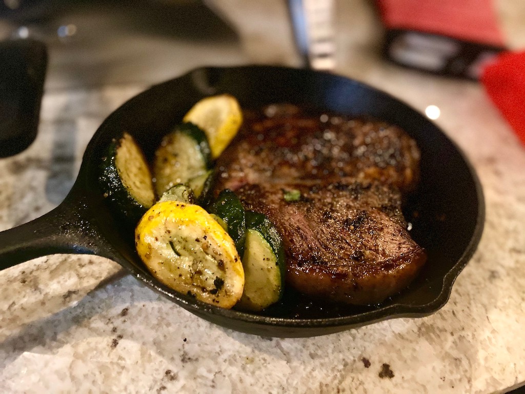 steak and veggies in cast iron pan 