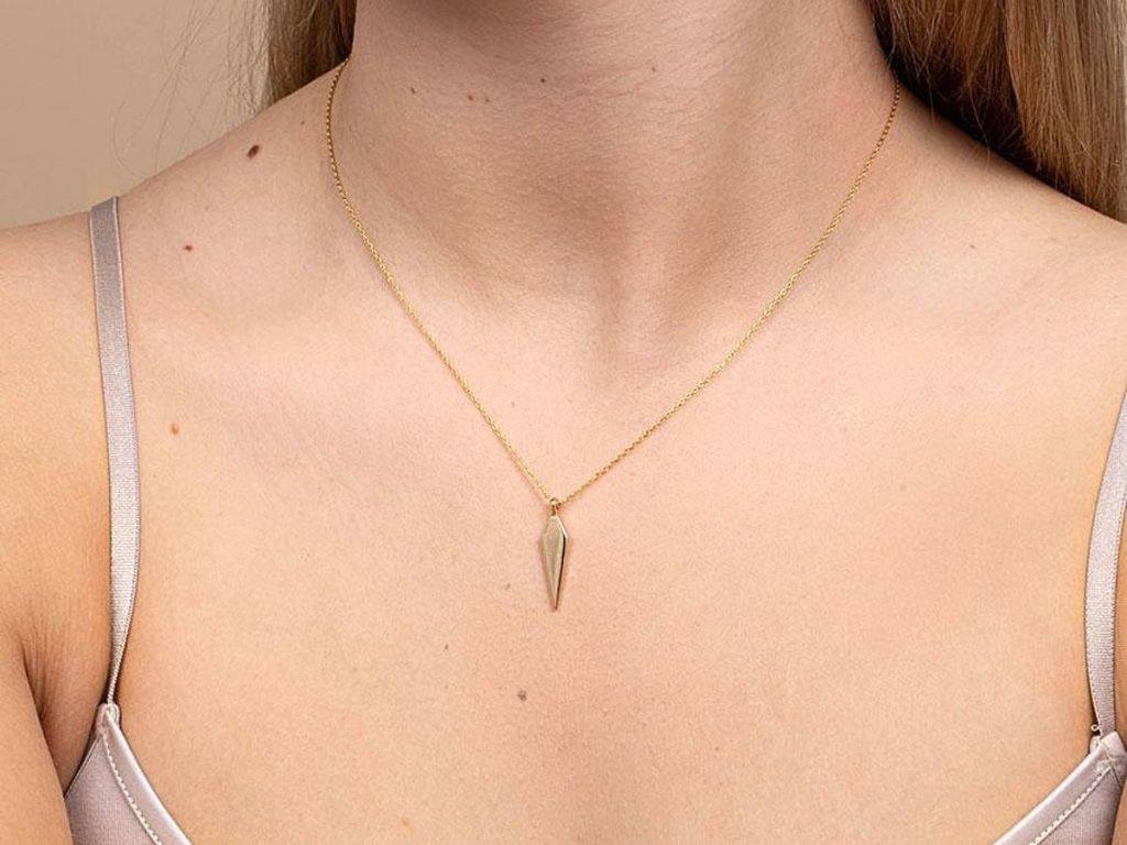 woman wearing gold arrow necklace