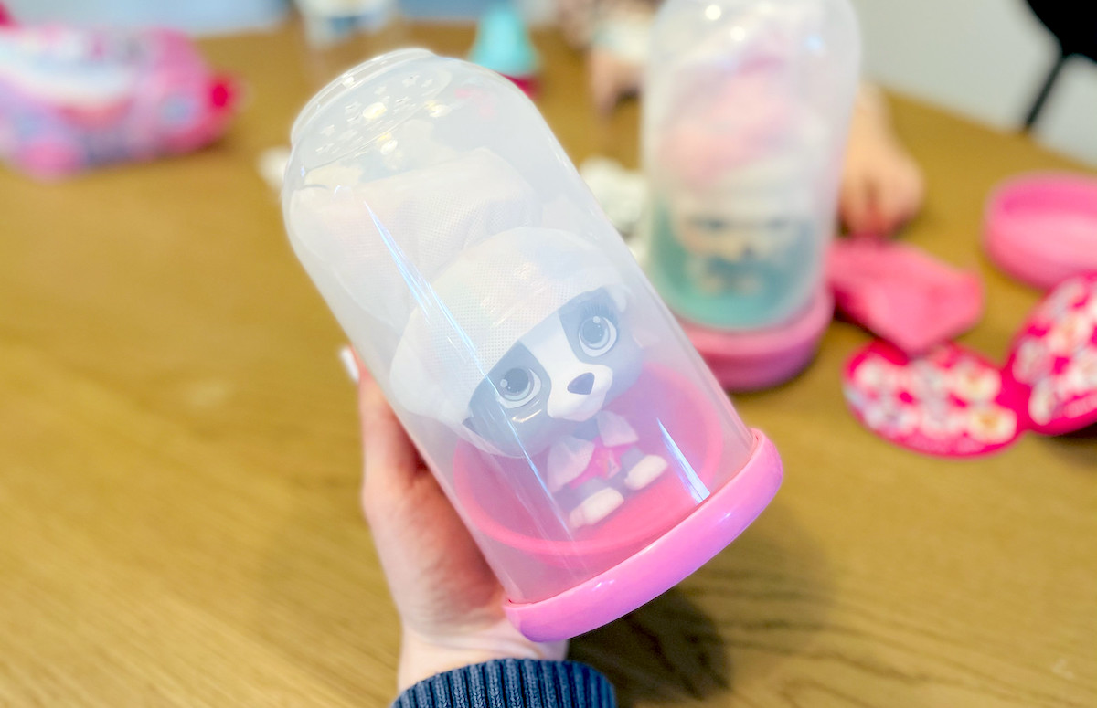 hand holding clear bottle with plastic toy inside