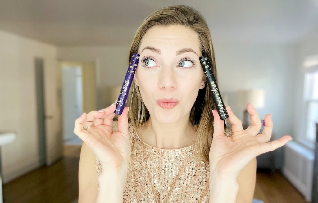 woman holding winky lux mascaras next to face